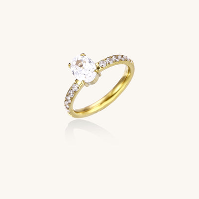 14K gold-plated ring with oval zirconia center stone and pavΓ© band accent stones on white background.