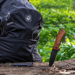 Personalized Engraved Wood Handle Pocket Knife - Lifestyle Shot Standing in Wood Near Black Backpack | Our Phoenix Rise
