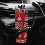 Christmas-themed tumbler with plaid design and text in a car cup holder.