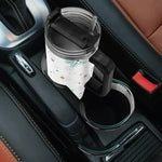 Colorful Snowflake 40oz Tumbler Car cup holder with a drink and straw, placed in a vehicle's console.