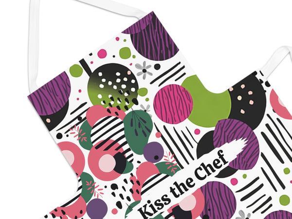 Colorful apron with geometric pattern and 'Kiss the Chef' text on a white background