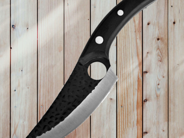 Large knife with a black handle on a wooden background