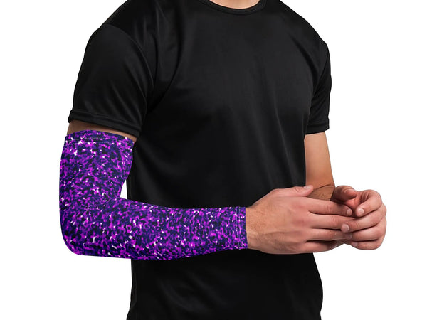 Person wearing a black shirt with a purple glittery arm sleeve on a white background