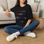 Person wearing a black t-shirt with a colorful graphic design, sitting on the floor in a living room.