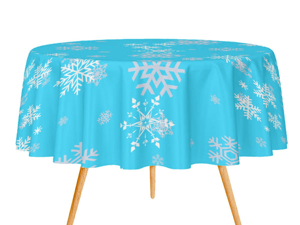 Round table with a blue tablecloth featuring white snowflake patterns on a white background