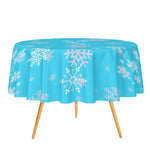 Round table with a blue tablecloth featuring white snowflake patterns on a white background