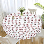 Round table with a decorative tablecloth featuring penguin and snowflake pattern, surrounded by white chairs.