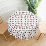 Round table with a decorative tablecloth featuring snowmen and snowflakes on a white background.