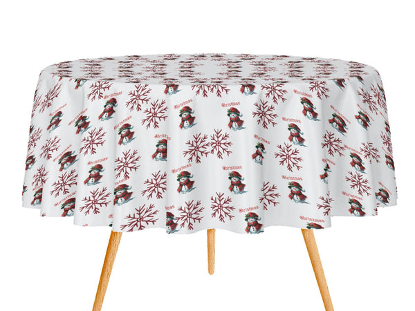 Round table with a festive tablecloth featuring snowmen and snowflakes on a white background