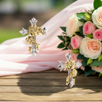 Gold and silver floral earrings on a wooden surface with pink and white roses in the background.