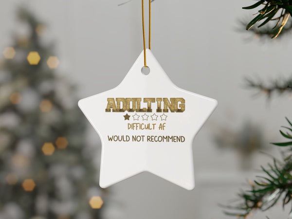 Star-shaped ornament with humorous text hanging on a Christmas tree.