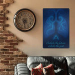 Wall clock and motivational poster on a wall with a couch and decorative pillows.