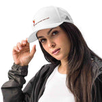 Woman wearing a white cap with a logo, posing against a white background