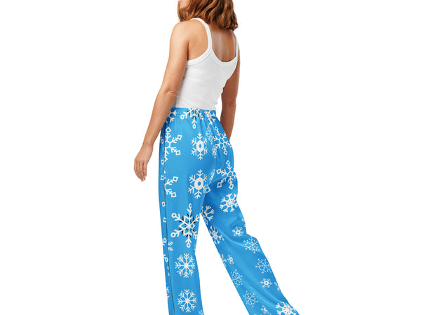 Woman wearing blue snowflake-patterned pants on a white background
