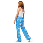 Woman wearing blue snowflake-patterned pants on a white background