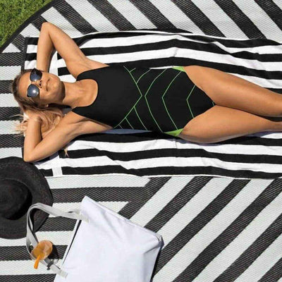 Black Neon Green One Piece Swimsuit - Woman on striped towel, front view | Our Phoenix Rise